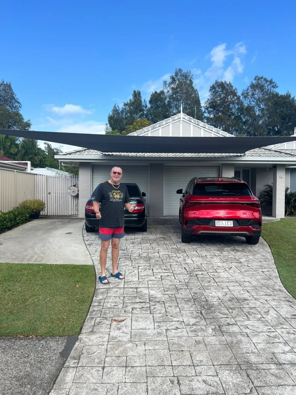 A broad carport sail spanning the front of a double garage.