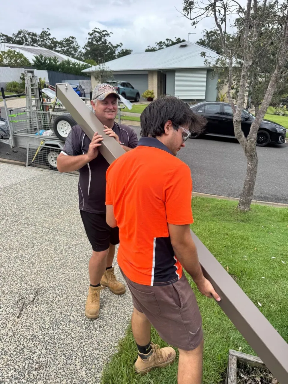 Thomas and Fran carrying a structural post together